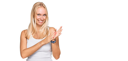 Canvas Print - Young blonde girl wearing casual style with sleeveless shirt clapping and applauding happy and joyful, smiling proud hands together