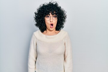 Poster - Young middle east woman wearing casual white tshirt afraid and shocked with surprise expression, fear and excited face.