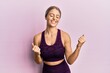 © Krakenimages.com - Beautiful blonde woman wearing sportswear over pink background very happy and excited doing winner gesture with arms raised, smiling and screaming for success. celebration concept.