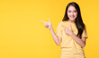 © kaew6566 - Cheerful young woman use finger pointing to product or empty copy space while standing over isolated on yellow background