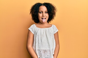 Poster - Young little girl with afro hair wearing casual clothes sticking tongue out happy with funny expression. emotion concept.