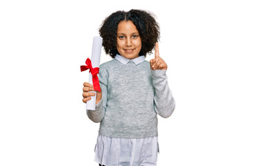 Wall Mural - Young little girl with afro hair holding graduate degree diploma surprised with an idea or question pointing finger with happy face, number one