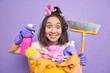 © wayhome.studio  - Cleanup and washing time concept. Cheerful surprised young Asian woman poses with dispenser and broom supplies regular cleaning of house washes laundry uses chemical detergents poses indoor.