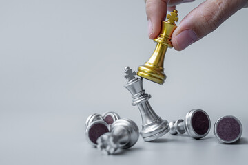 Wall Mural - businessman hand moving gold Chess King figure and Checkmate opponent during chessboard competition. Strategy, Success, management, business planning, disruption and leadership concept