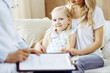 © rogerphoto - Doctor and patient. Pediatrician using clipboard while examining little girl with her mother at home. Happy cute caucasian child at medical exam. Medicine concept