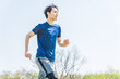 © HML - 公園でランニングをする若い男性