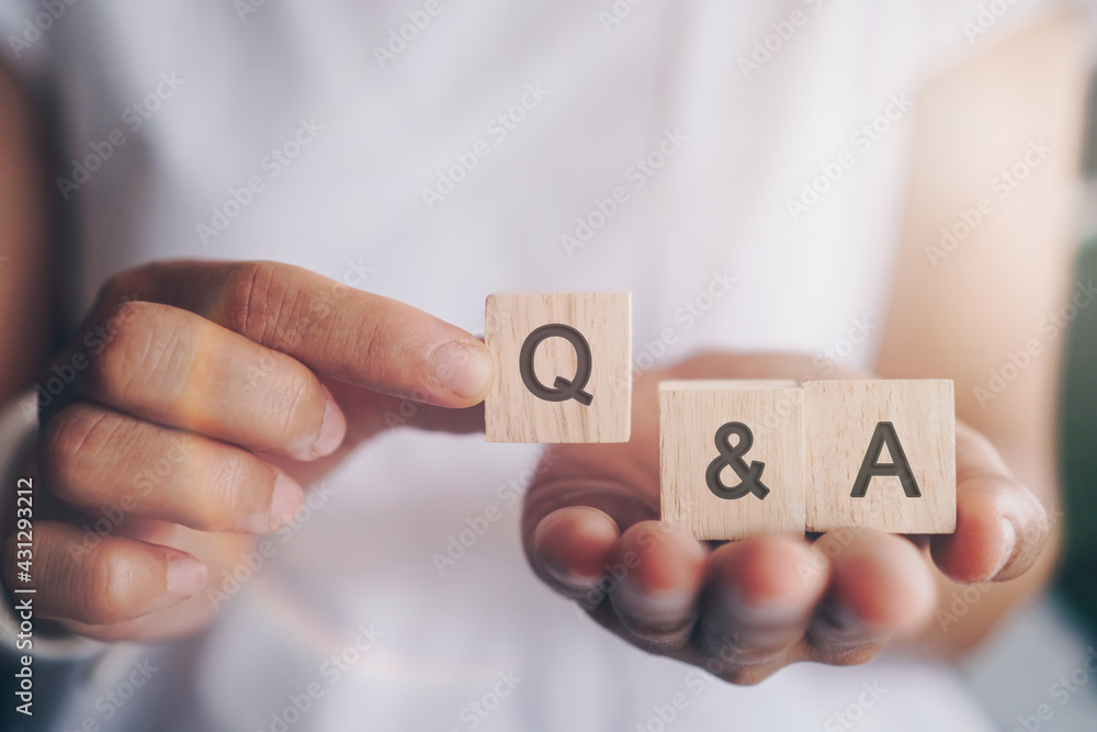 Q and A alphabet on wooden cube in hand hold with background. Question and answer meaning. - obrazy, fototapety, plakaty 