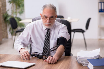 Aged male employee suffering at workplace