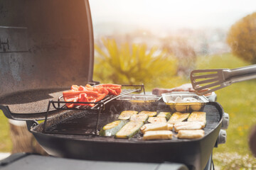 Vegetarian BBQ on weekend. Grill cheese and vegetables on gas grill. Outdoors.