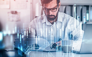 Wall Mural - Handsome beard trader in glasses analyzing stock graph chart and taking notes to predict the movement, fundamental analysis, front view of working businessman. Double exposure. Internet trading