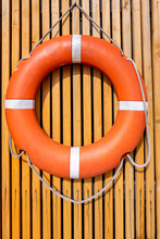 An Orange Lifebuoy On A Wooden Slat Wall.  Copy Space. Safety Concept