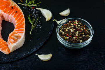 Wall Mural - Raw salmon steak and spices on a slate board