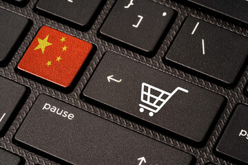 China flag and White Trolley or shopping cart icon print screen on button computer laptop keyboard , Shopping online and e-commerce concept.