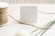 Mockup scene with herbs, vintage spool of cotton braid and white empty paper card with copy space.