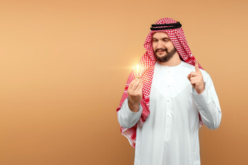 Wall Mural - A Saudi Arab man holds a light bulb in his hand as a symbol of the idea in national dress. Dishdasha, kandora, thobe, islam. Copy space.