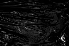 A Transparent Plastic Wrap On Black Background. Realistic Plastic Wrap Texture For Overlay And Effect. Wrinkled Plastic Pattern For Creative And Decorative Design.