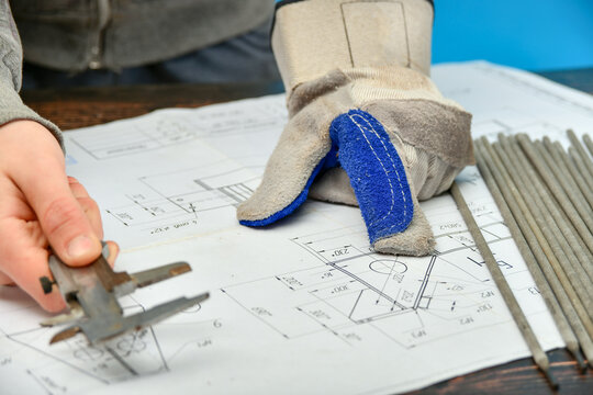 a young welder examines an assembly drawing before work.