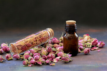 Sticker - Small rose buds and rose oil in bottle on wooden table