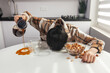 © uladzislaulineu - Sleepy woman falls asleep at the kitchen table during breakfast and pours coffee past the mug