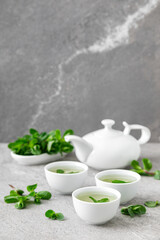 Poster - Herbal mint tea in small traditional chinese cups and fresh leaves, healthy antioxidant drink