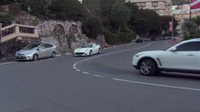 Tracking A Luxury Sports Car As It Quickly Moves Along A Winding Street With Amazing Monte Carlo Buildings And Landscape In The Background