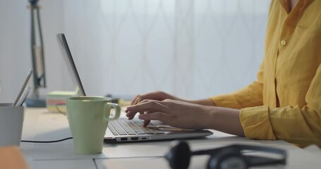 Wall Mural - Woman sitting at desk and connecting with her laptop