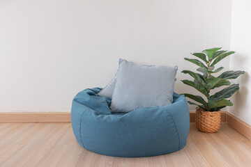 Blue bean bag in a clear living room with wooden floor and clear white wall.