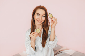 Wall Mural - girl make homemade face beauty masks. cucumbers for the freshness of the skin around the eyes. woman