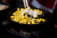 Hand Hold Chopsticks With Cheese Mix On Seed Corn In Hot Pan
