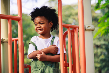 Wall Mural - Cute African American little kid boy funny while playing on the playground in the daytime in the spring season. Outdoor activity. Playing make-believe the concept. Outside education