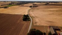 4K DRONE footage of a car driving away into the distance. In the car is a newly married couple. There's three clips stitched together for you.