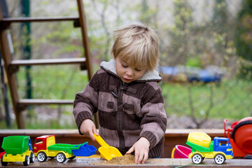 Sticker - Toddler child, boy, playing in sandpit at backyard