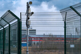 Fototapeta Do przedpokoju - A metal lattice fence and security cameras guard the area. Fence, great design for any purpose. The concept of safety of industrial territories.