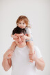 © andrey - little daughter sits on his father's shoulders and closes his eyes with hands