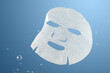 © zhane luk - a facial sheet mask under water on blue background. skin care concept.