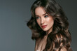 © Utkamandarinka - Beautiful woman with long hair, shine and curly, beauty girl female over darl gray background