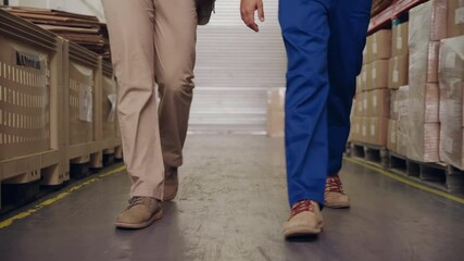 Wall Mural - Low section of two employee workers walking in warehouse towards camera