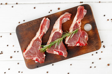 Wall Mural - Raw meat ribs on wooden board on white background