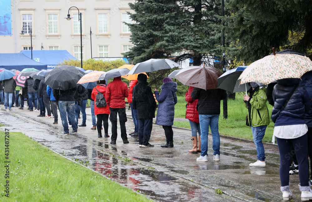 Ludzie pod parasolami czekają w kolejce do mobilnego punktu szczepień we Wrocławiu.  - obrazy, fototapety, plakaty 