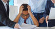 © TommyStockProject - Exhausted tired little businessman sitting at desk, colleagues shaking papers in face