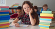 © TommyStockProject - Asian preteen schoolgirl studying in classroom sitting at desk.