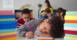 © TommyStockProject - Tired african child sleeping while studying in the primary school classroom.
