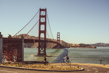Couple Riding Bikes The Golden Gate Bridge In San Francisco, United States Of America Aka USA