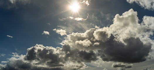 Wall Mural - beautiful wide panoramic view of cloudy sky with bright sun above