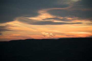 Wall Mural - Colorful sunset over the mountain hills. Beautiful clouds flying over the lake near mountains. Evening time shot over the clouds. Baku, Azerbaijan.