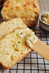 Sticker - Closeup shot of delicious cheese bread with herb butter on a white table