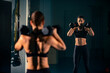 © MexChriss - A young female doing exercise with a two dumbbell in front of a mirror