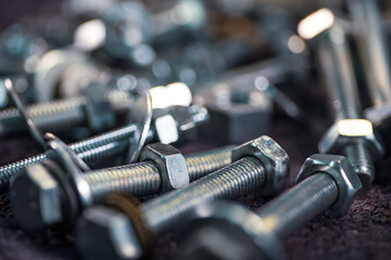 Metal chrome bolts and nuts in a chaotic order industrial background