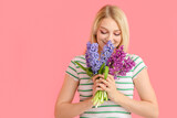 Fototapeta Tulipany - Beautiful young woman with hyacinth flowers on color background