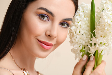 Sticker - Beautiful young woman with hyacinth flowers on light background